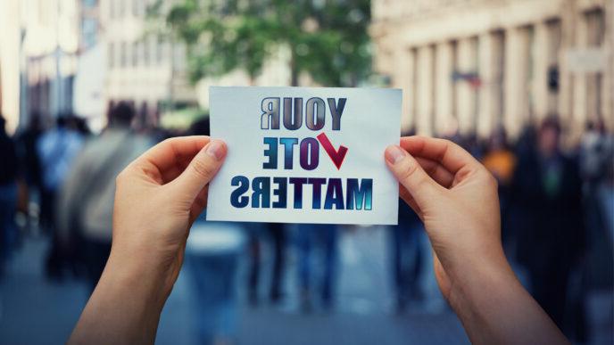 photo of hands hold a paper sheet with the message your vote matters